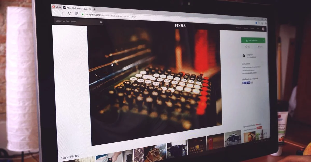 Un bureau moderne avec un moniteur d'ordinateur affichant une image d'une machine à écrire vintage, mettant en avant un environnement de travail.