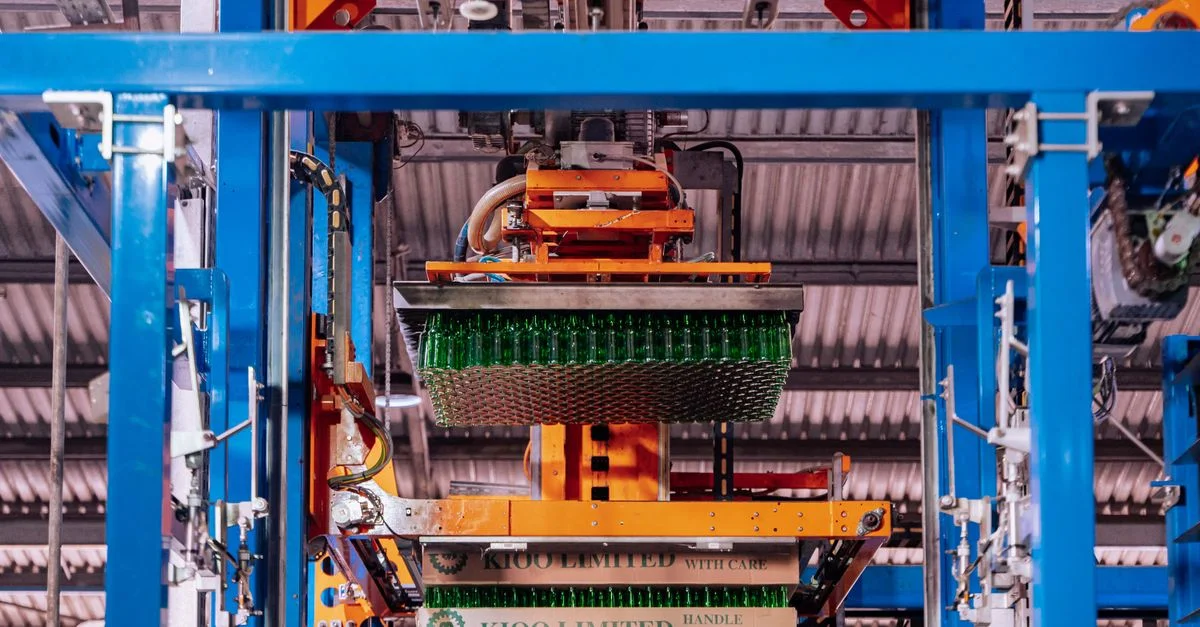 Processus de fabrication du verre dans une usine de Dar es Salaam, présentant des machines automatisées.