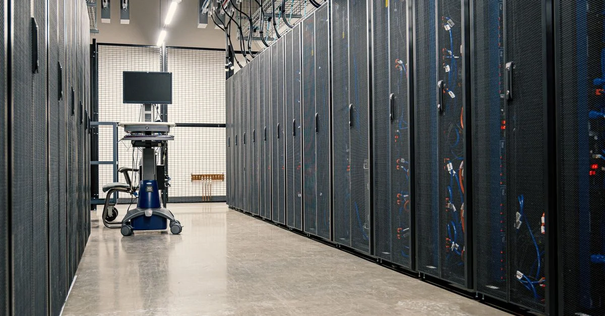 Couloir moderne d'un centre de données avec des racks de serveurs et du matériel informatique. Idéal pour des concepts de technologie et d'informatique.