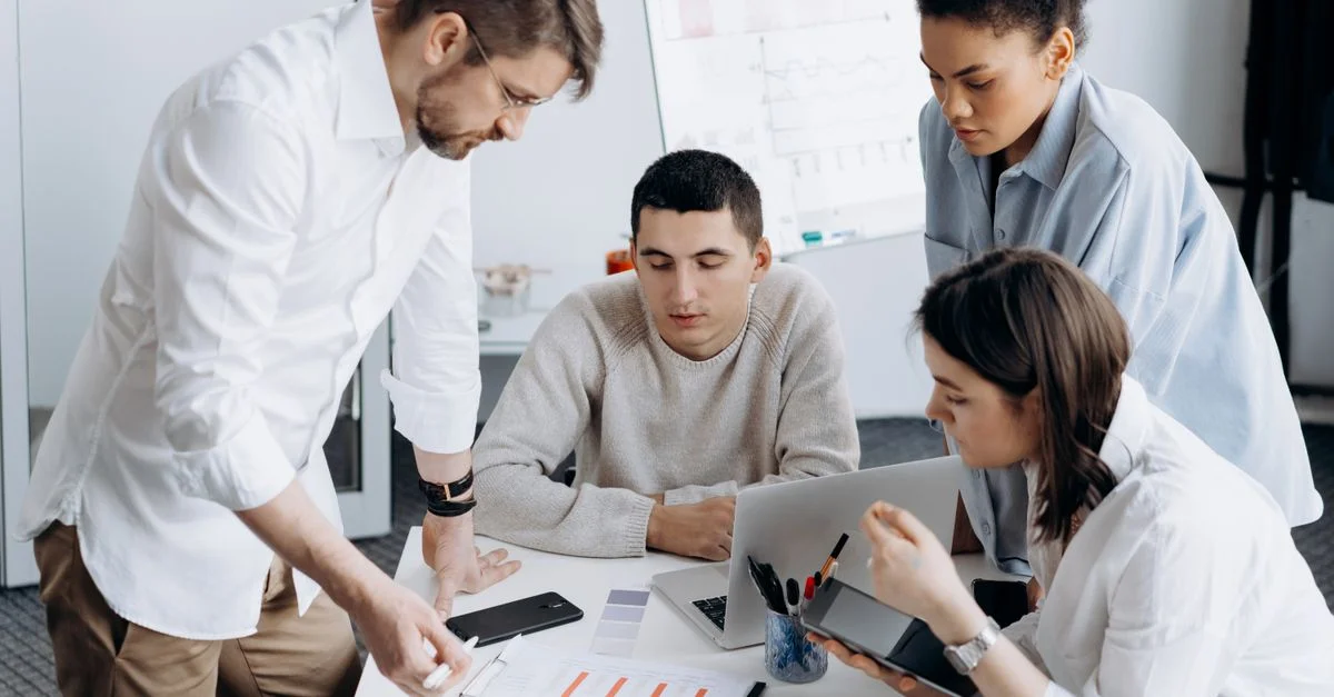 Un groupe de professionnels en brainstorming et travaillant ensemble dans un bureau contemporain.