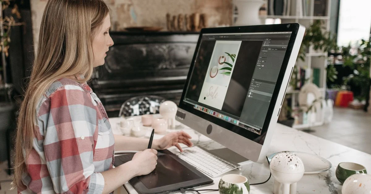 Femme utilisant une tablette graphique dans un bureau élégant, concentrée sur le design graphique.
