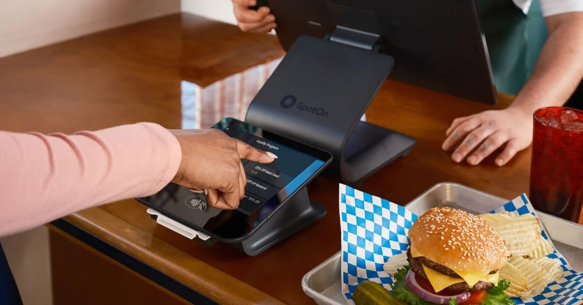 Comptoir de restaurant avec système POS SpotOn et repas de burger, mettant en avant l'interaction avec les clients.