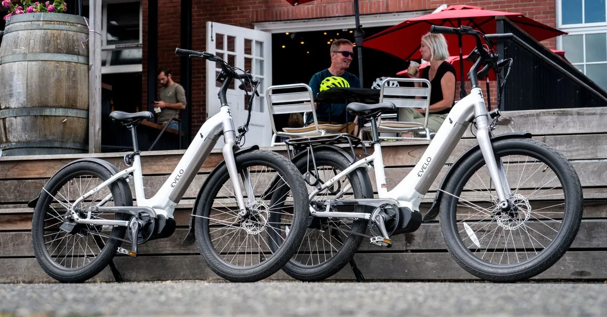 Deux vélos électriques garés à l'extérieur d'un café à Seattle avec des personnes en arrière-plan.