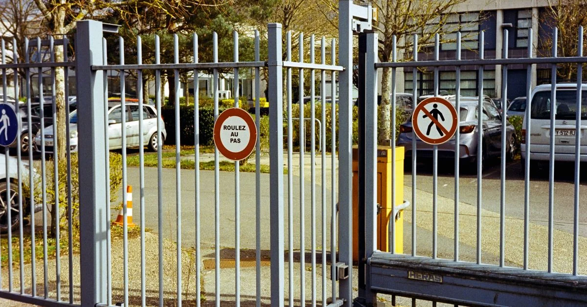 Portail en métal à Compiègne, France, comportant des panneaux de contrôle de la circulation. Cadre urbain, en plein jour.