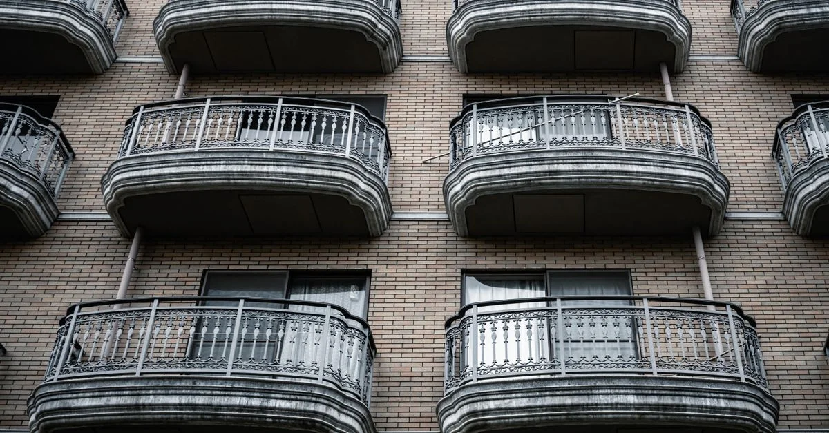 Vue symétrique de balcons ornés sur la façade d'un immeuble d'appartements en briques.