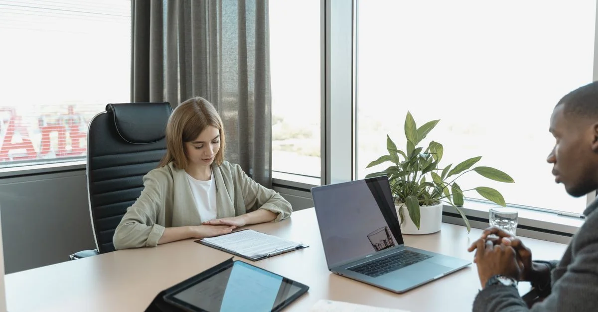 Un scénario d'entretien d'embauche diversifié dans un bureau moderne avec un ordinateur portable et des documents sur la table.