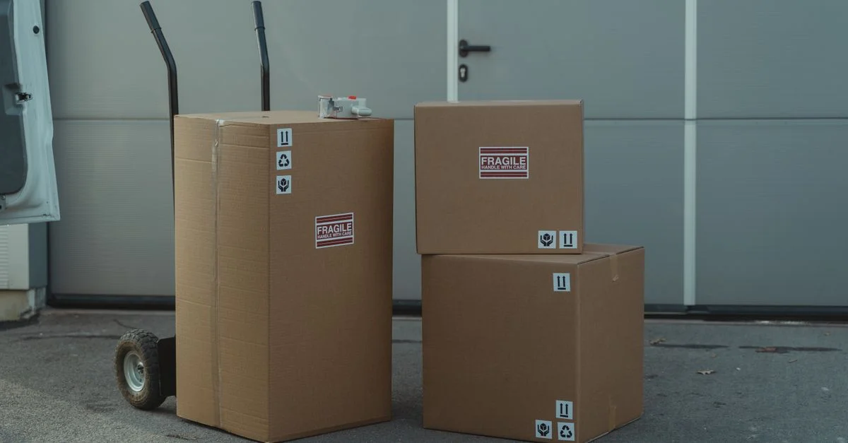 Trois cartons sur un chariot, prêts à être expédiés à l'extérieur d'un entrepôt.