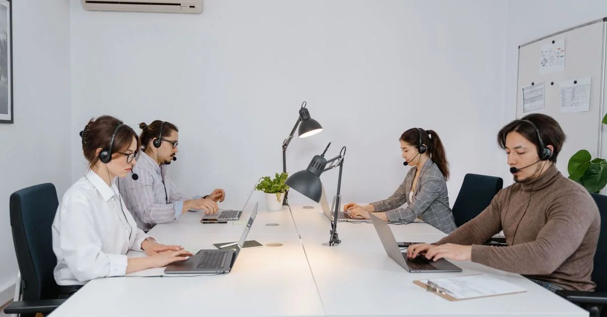 Un groupe diversifié de professionnels travaillant sur des ordinateurs portables dans un bureau moderne de centre d'appels.
