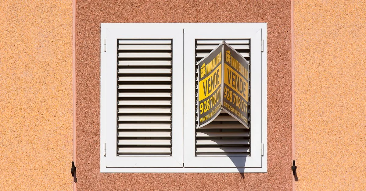 Fenêtre à volets blancs avec un panneau à vendre sur l'extérieur d'un bâtiment pêche.