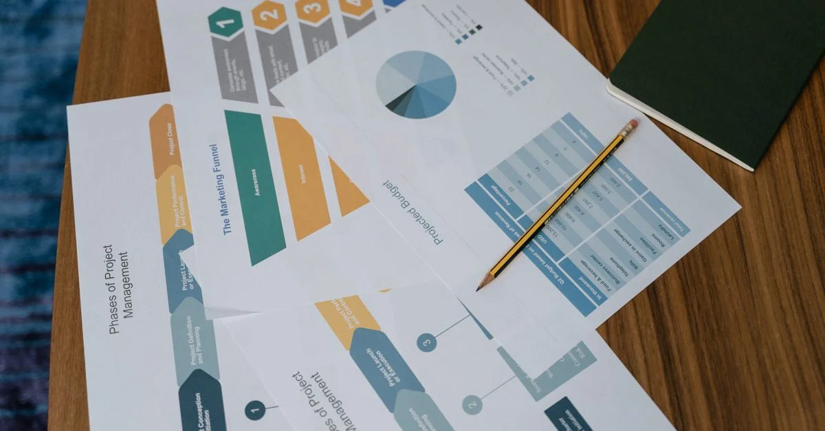 Vue de dessus de documents de gestion de projet et de graphiques sur un bureau avec un crayon.