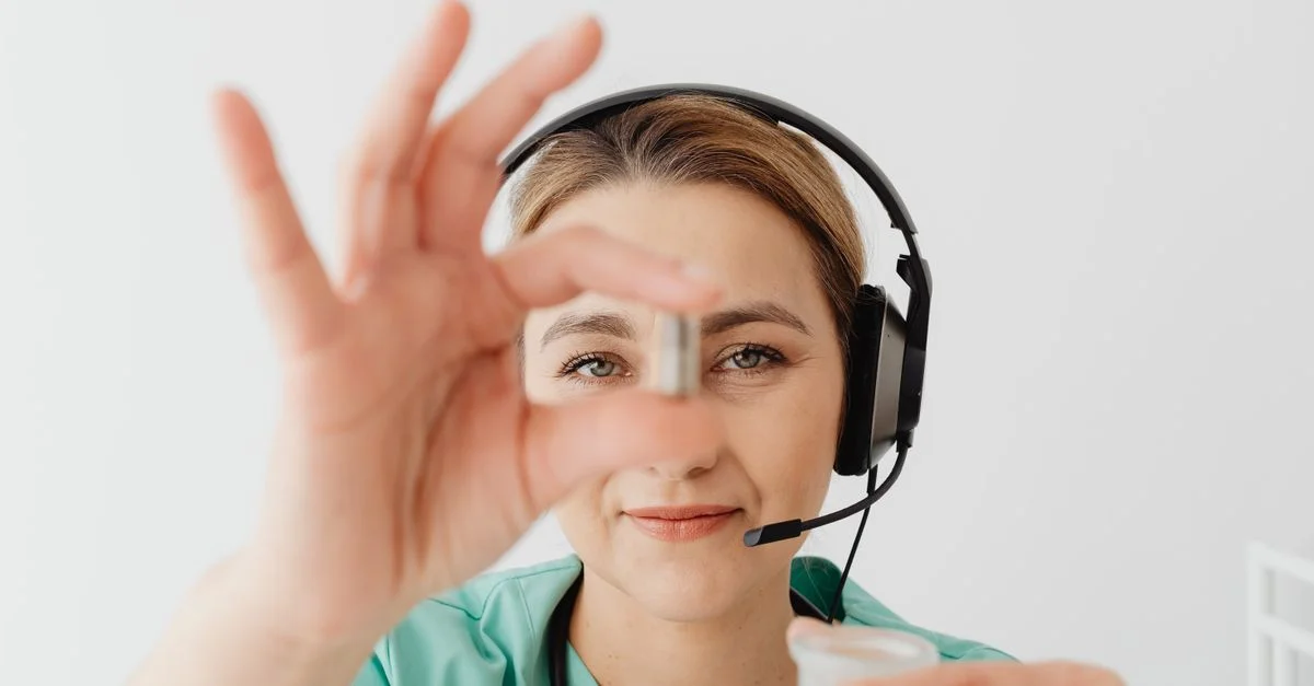 Médecin femme en casque tenant une pilule lors d'une consultation médicale en ligne, soulignant la télémédecine.