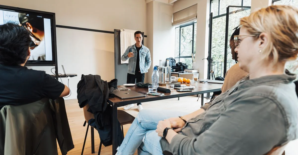 Un groupe de professionnels engagés dans une présentation dynamique dans un bureau moderne et lumineux.