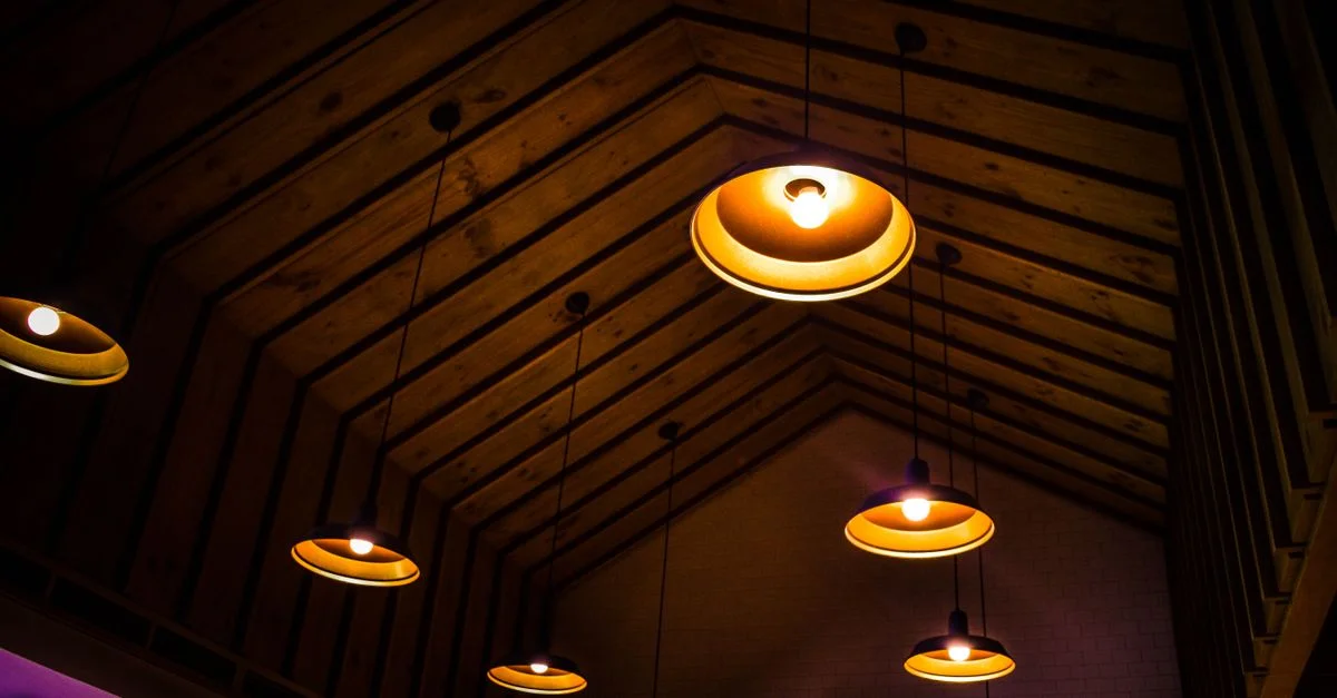 Un plafond en bois rustique intérieur orné de lampes suspendues illuminées chaleureusement.