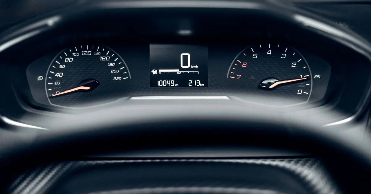 Vue détaillée d'un tableau de bord de voiture moderne montrant le compteur de vitesse, le compteur kilométrique et le compte-tours.
