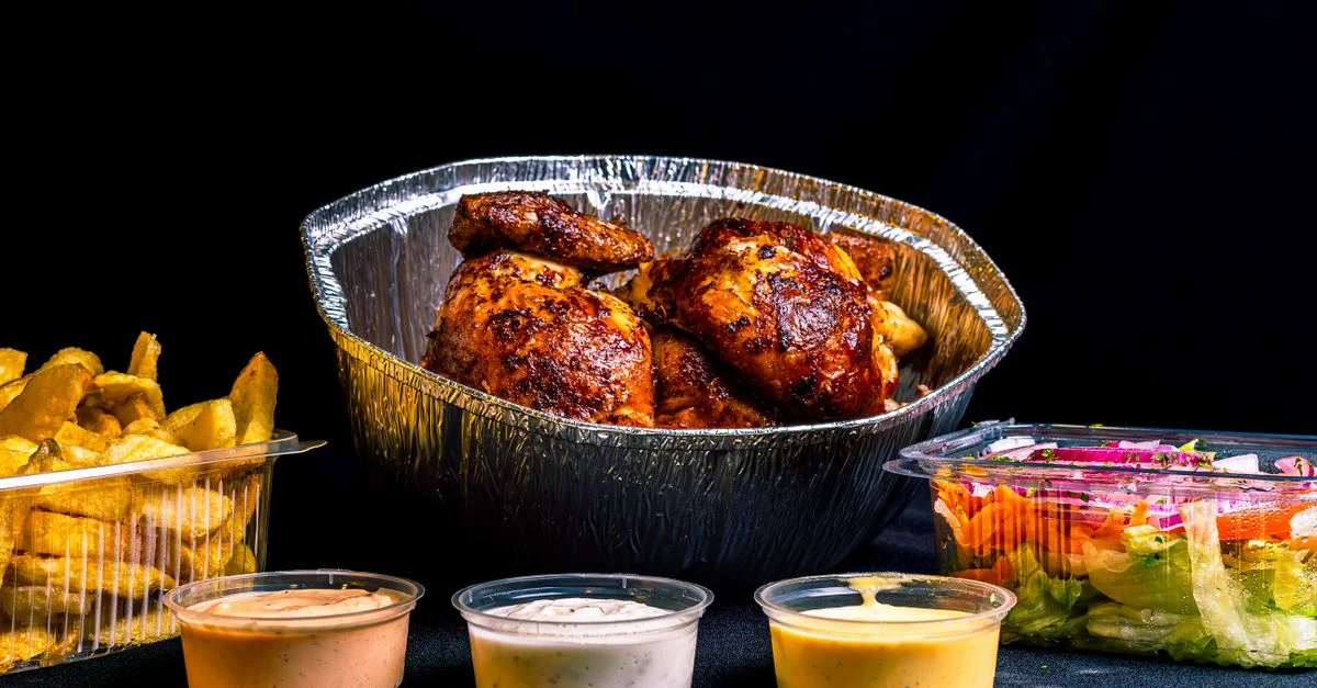 Poulet rôti servi avec des sauces, des frites et une salade, parfait pour un festin copieux.