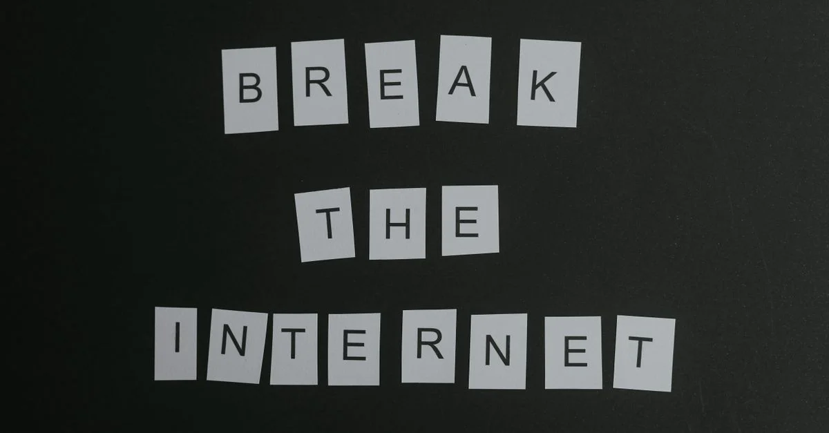 Composition conceptuelle à plat du message 'Break the Internet' avec des lettres blanches sur un fond noir.
