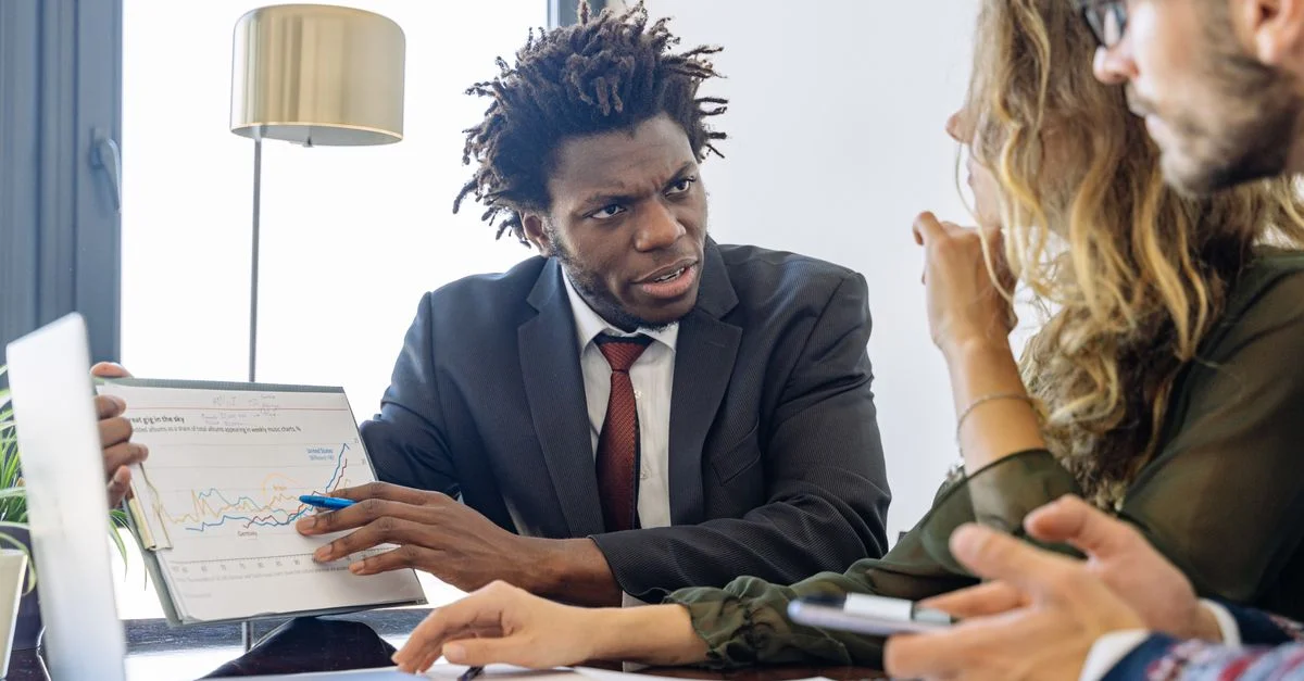 Des professionnels du business discutant de données financières lors d'une réunion collaborative.