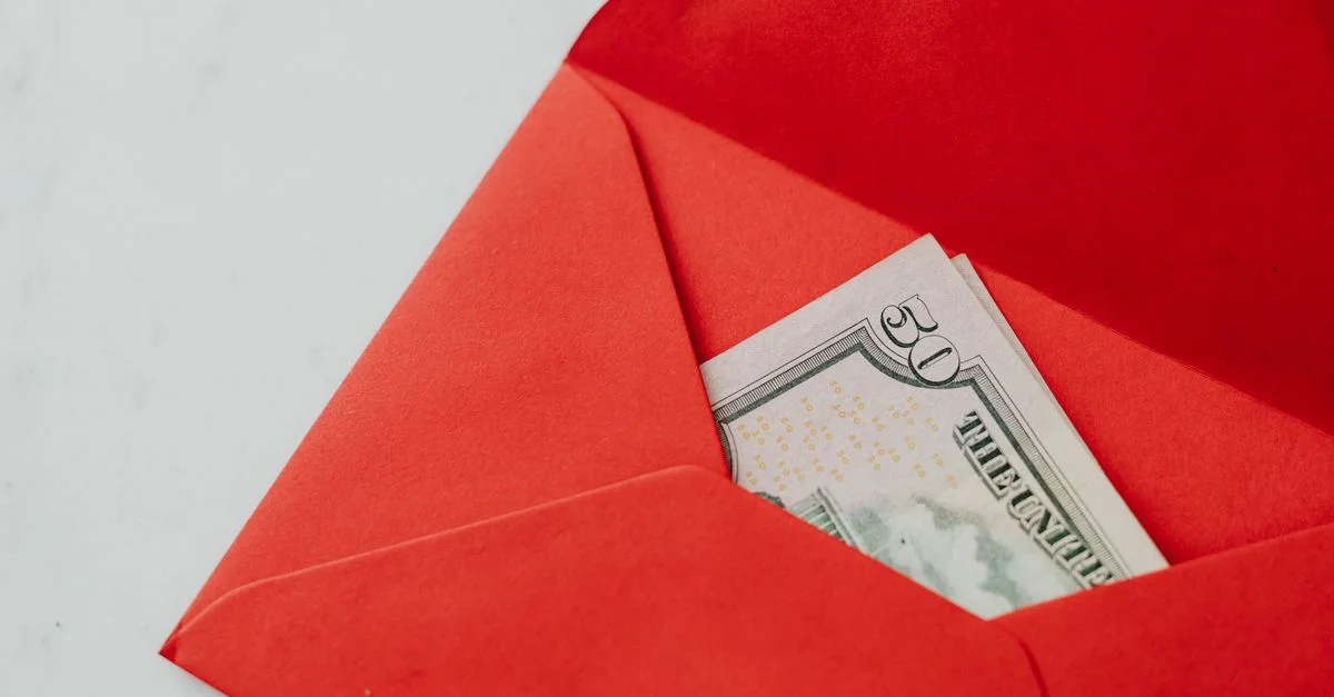 Gros plan sur un billet de cinquante dollars dans une enveloppe rouge vibrante, idéal pour une photo de stock sur les cadeaux ou les échanges d'argent.