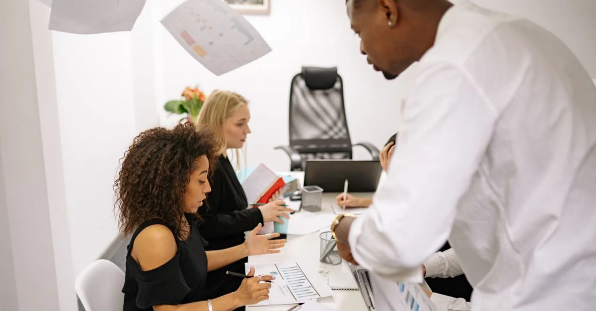 Un groupe divers d'adultes engagé dans une réunion collaborative au bureau avec des documents sur la table.