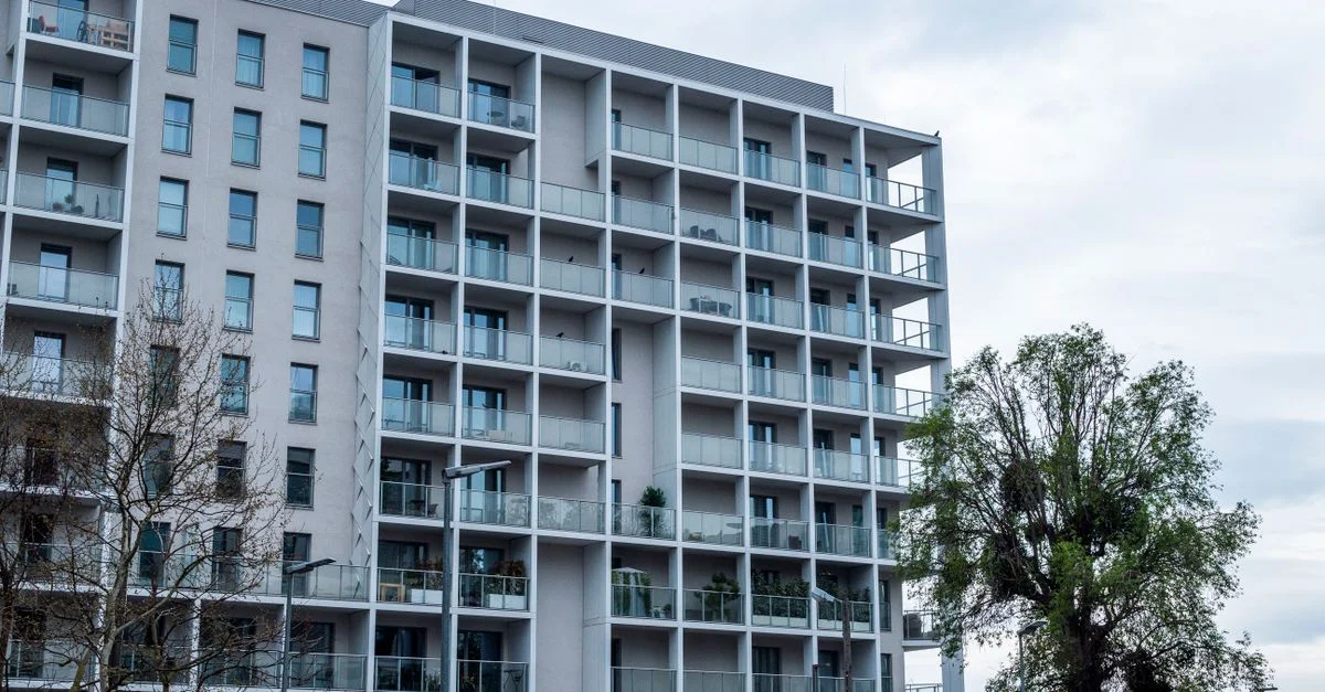 Immeuble d'appartements contemporain à plusieurs étages avec balcons et grandes fenêtres.
