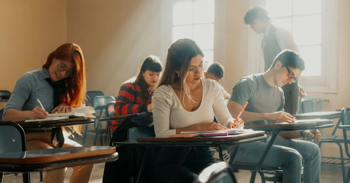 Des étudiants étudient dans une salle de classe ensoleillée de Buenos Aires, absorbés par leurs apprentissages.