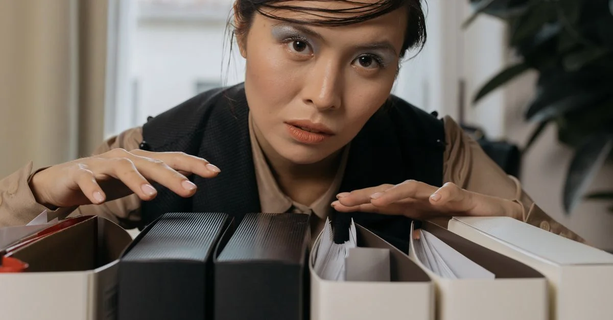 Femme organisant des dossiers dans un bureau, mettant en avant la concentration et l'efficacité. Parfait pour des thèmes d'affaires et de lieu de travail.