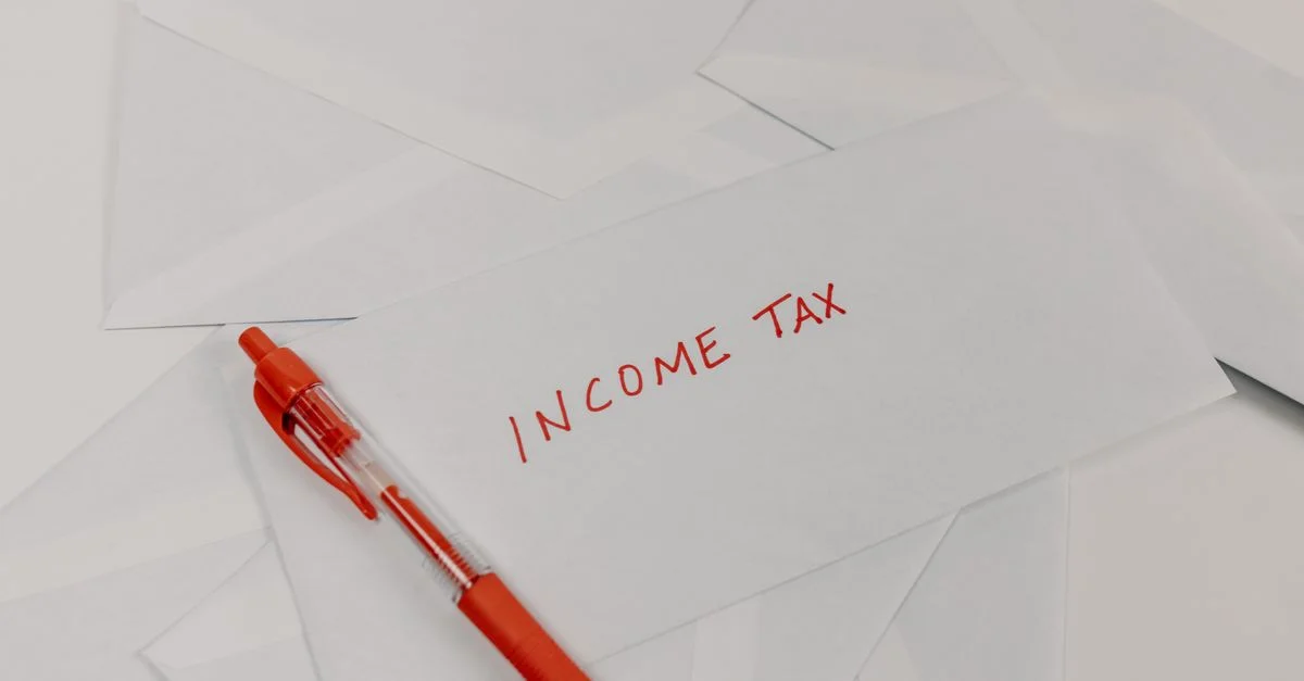 Photo en studio d'une enveloppe de déclaration fiscale avec un stylo rouge pour la comptabilité et la préparation de la saison fiscale.
