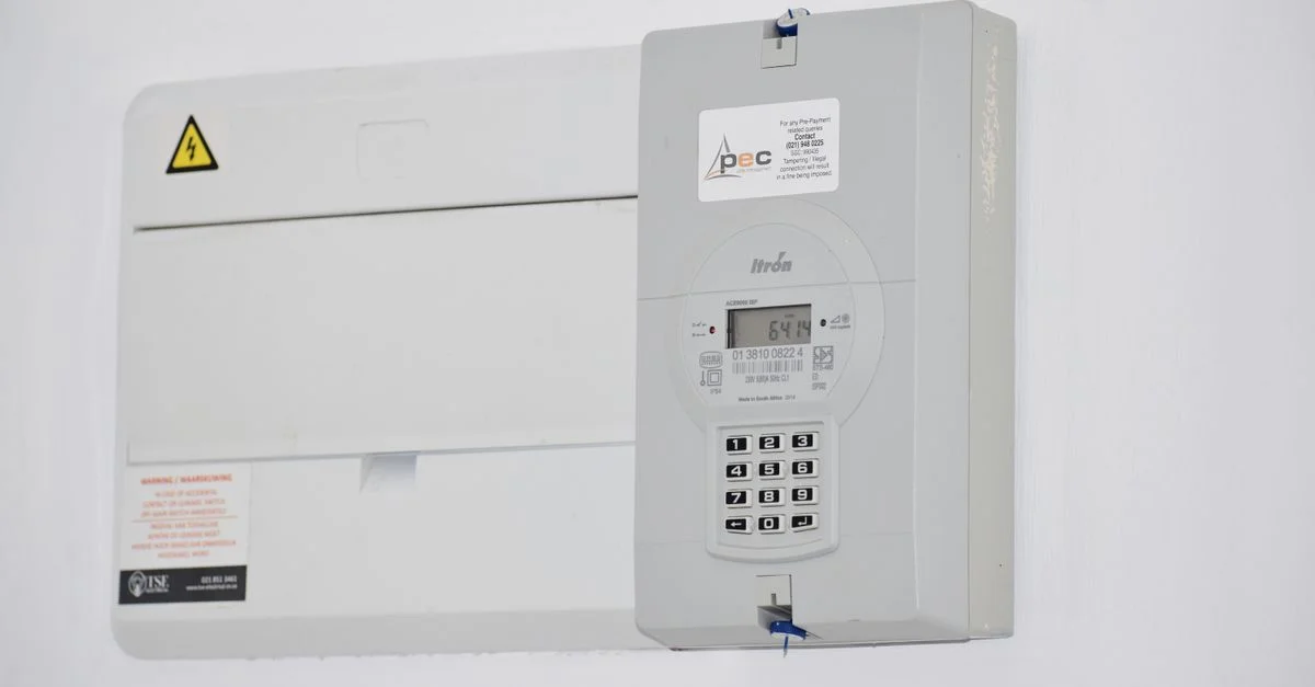 Compteur électrique et boîte à fusibles sur un mur blanc à Cape Town, Afrique du Sud, pour la surveillance de l'énergie ou la facturation.