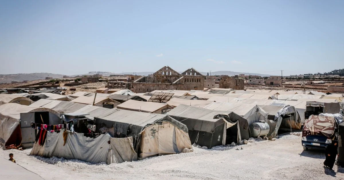 Un camp de réfugiés à Idleb, en Syrie, avec des tentes sous un ciel bleu clair, soulignant les efforts d'aide humanitaire.
