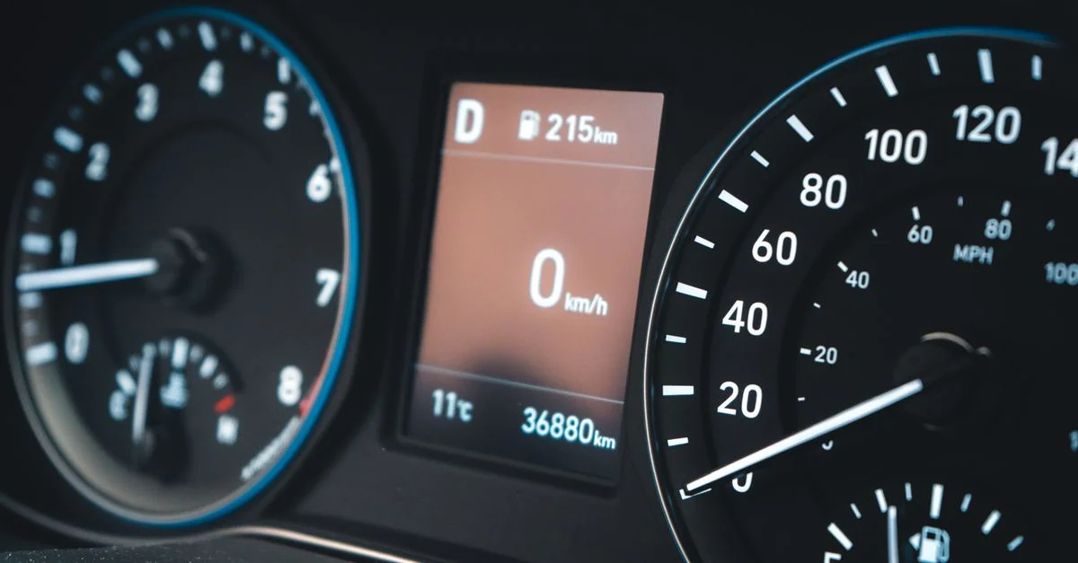 Vue détaillée d'un tableau de bord de voiture présentant un compteur de vitesse et un affichage numérique montrant 0 km/h.