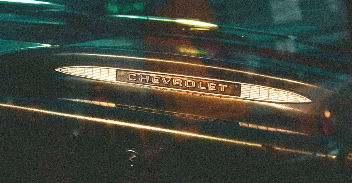 Gros plan sur un emblème Chevrolet sur le tableau de bord d'une voiture vintage, mettant en valeur un design rétro.