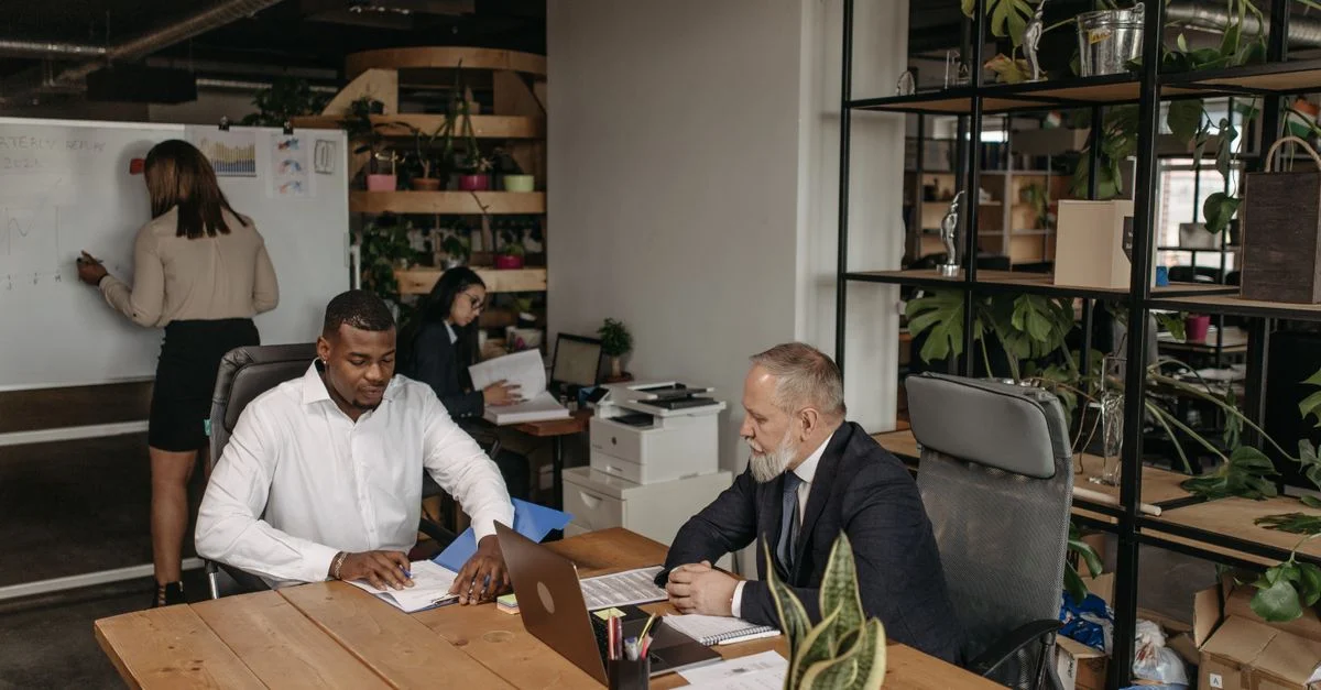 Équipe professionnelle engagée dans une réunion d'affaires avec des membres divers dans un environnement de bureau moderne.