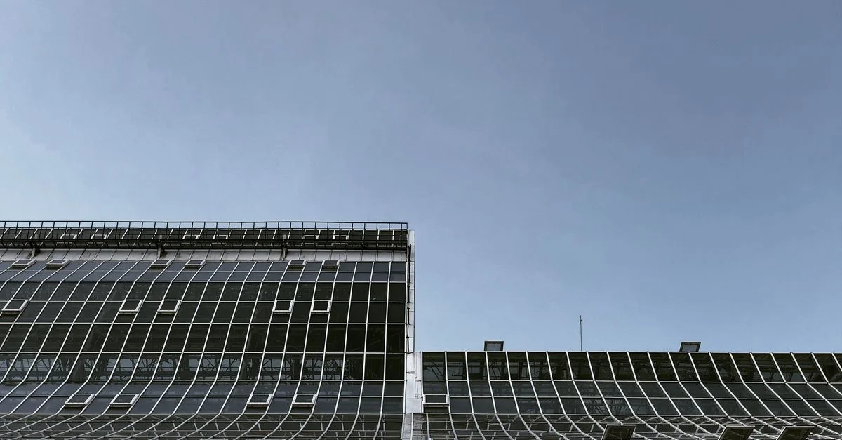 Bâtiment contemporain à Moscou avec une façade en verre contre un ciel bleu clair, vue en contre-plongée.