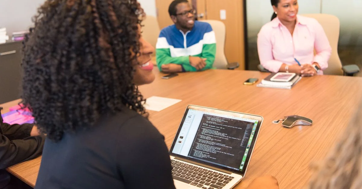 Un groupe diversifié de professionnels collaborant dans un environnement de bureau moderne avec des ordinateurs portables et de la technologie.