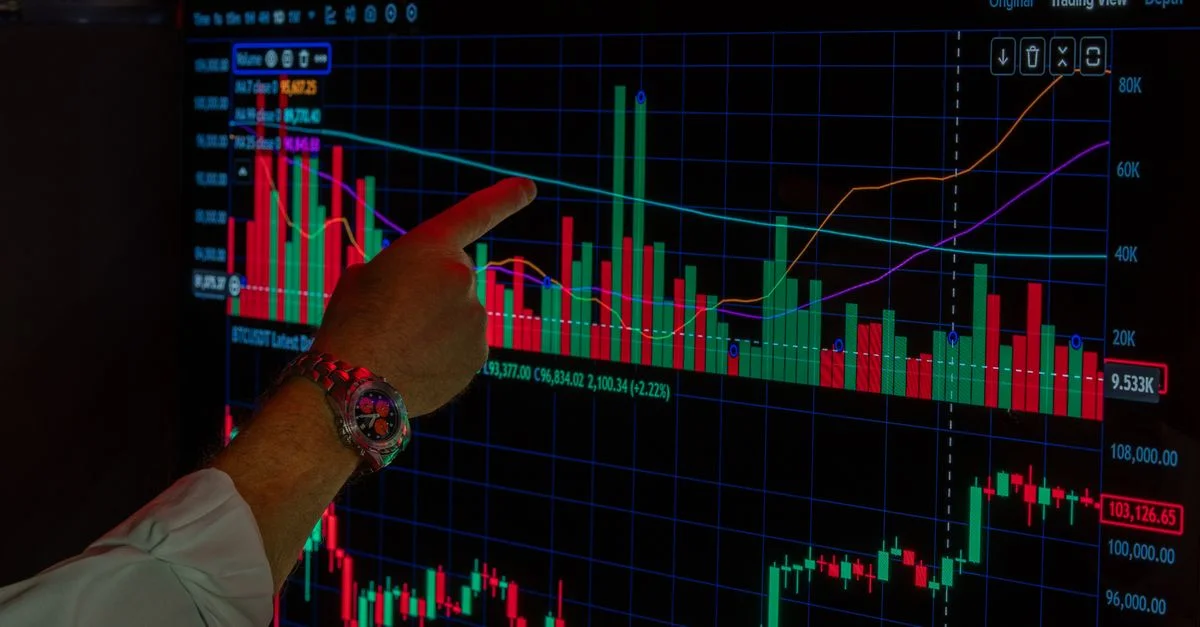 Gros plan sur une personne analysant les tendances du marché Bitcoin sur l'écran d'une plateforme de trading numérique.