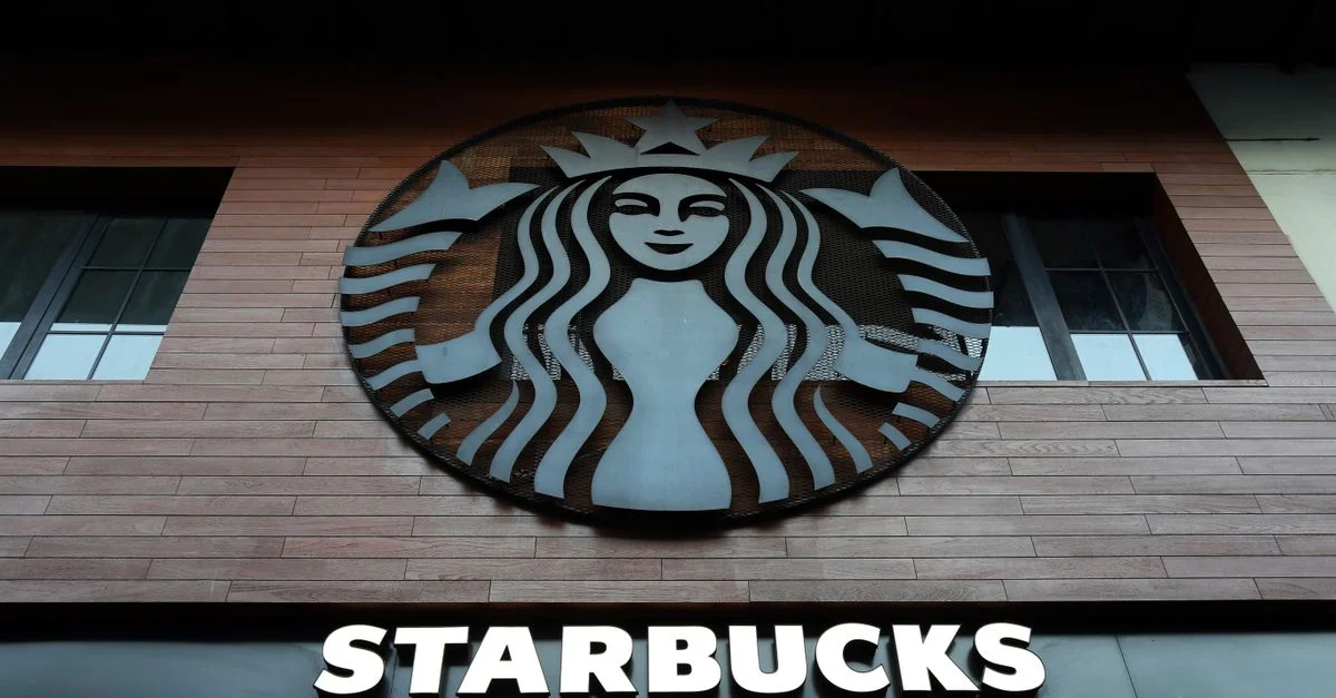 Photo en contre-plongée de l'extérieur d'un bâtiment Starbucks avec logo et fenêtres.