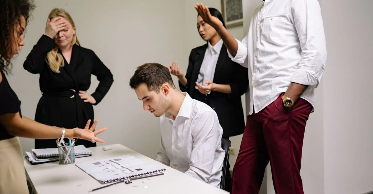 Des professionnels du secteur engagés dans une discussion tendue au bureau, mettant en évidence le conflit au travail.
