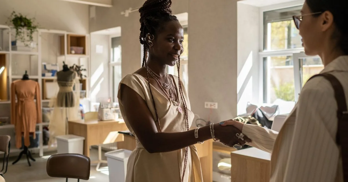 Femmes se serrant la main dans un studio de mode élégant lors d'une réunion.
