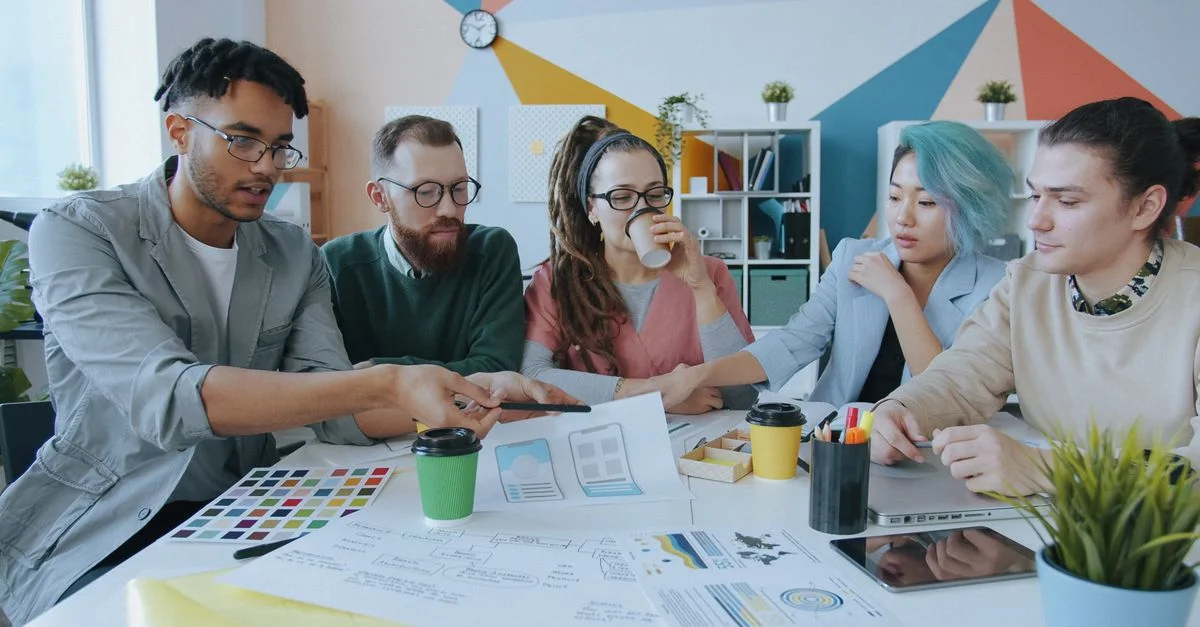 Un groupe diversifié de professionnels se réunit pour un brainstorming dans un environnement de bureau moderne et coloré.