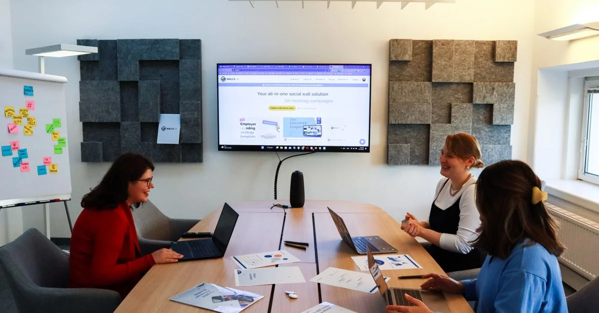 Une équipe de femmes collaborant lors d'une réunion d'affaires avec des ordinateurs portables et des présentations.