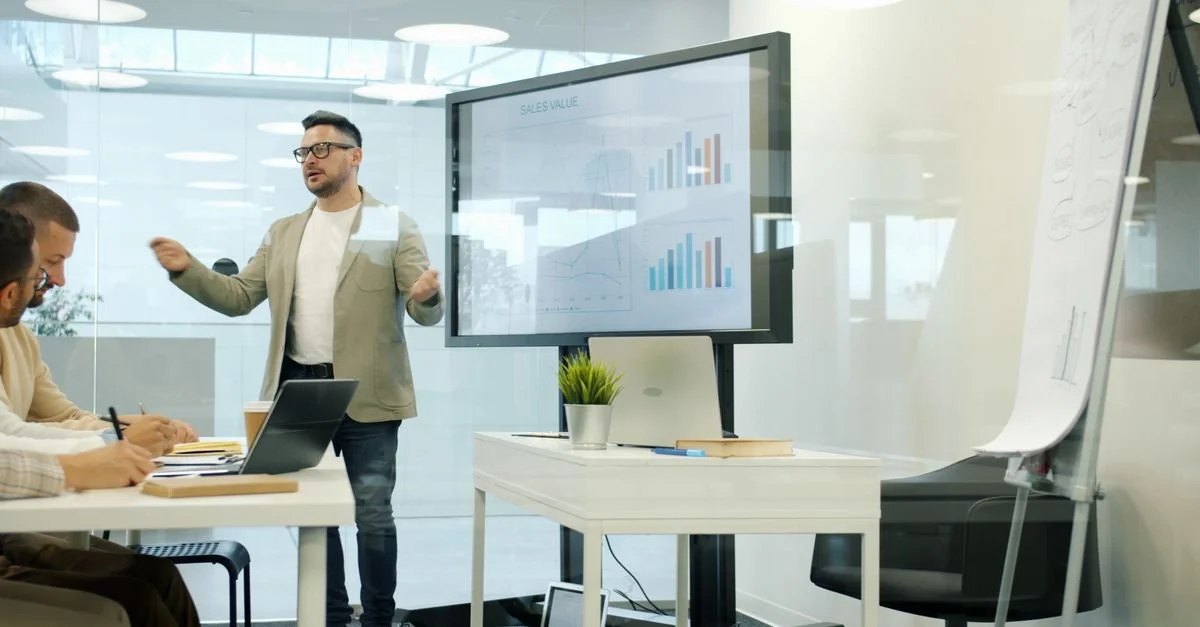 Présentation professionnelle des données de vente lors d'une réunion de bureau moderne.