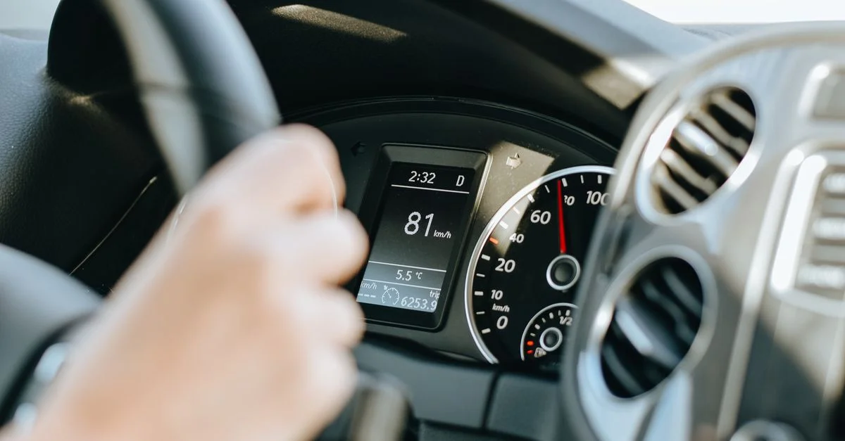 Détail d'un tableau de bord de voiture avec compteur de vitesse et volant en focus