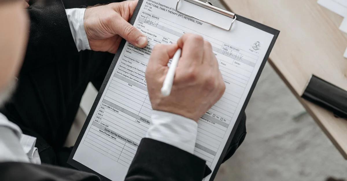 Gros plan d'un homme d'affaires signant un document formel sur un clip.