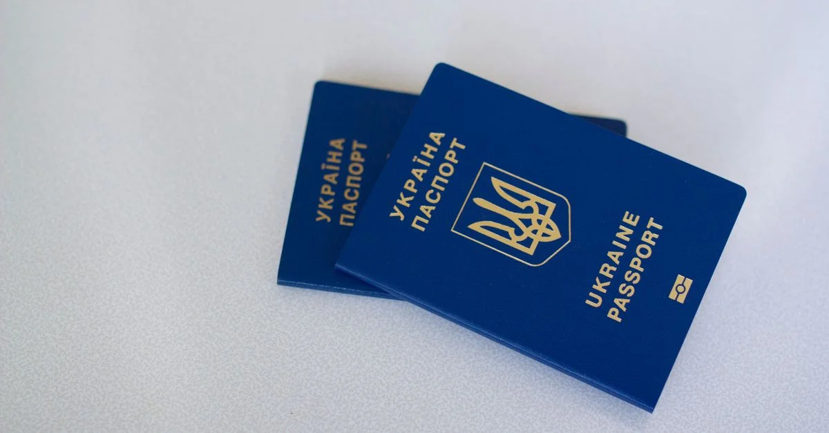 Image de deux passeports ukrainiens sur une surface blanche, mettant en avant les thèmes du voyage et de l'identification.