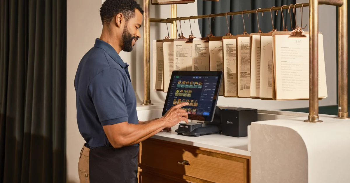 Un serveur de restaurant utilise un système de point de vente à écran tactile, ce qui améliore l'efficacité de la gestion des commandes.