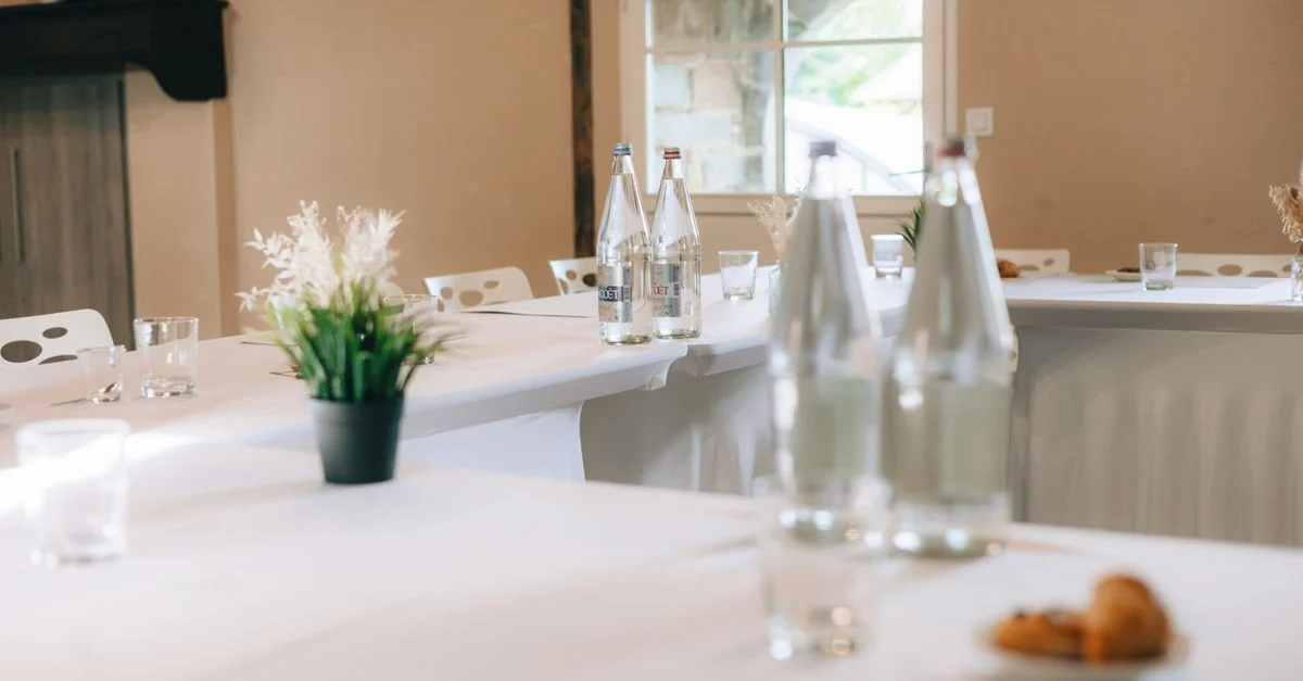 Configuration moderne de salle de conférence avec de l'eau en bouteille et des croissants, idéale pour des réunions.