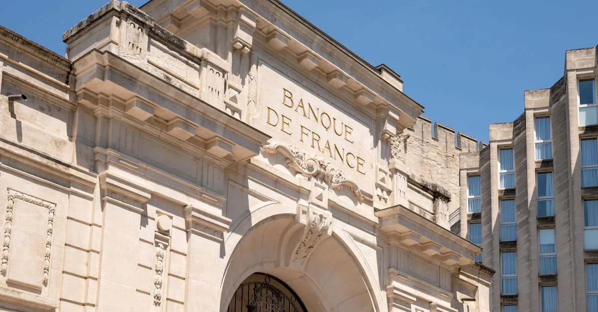 Élégante façade architecturale de la Banque de France à Avignon se détachant sur un ciel bleu azur.