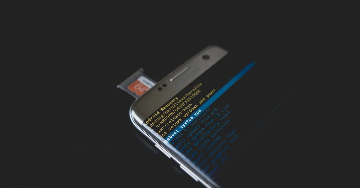 Gros plan sur un smartphone affichant le mode de récupération Android avec une carte SD insérée.