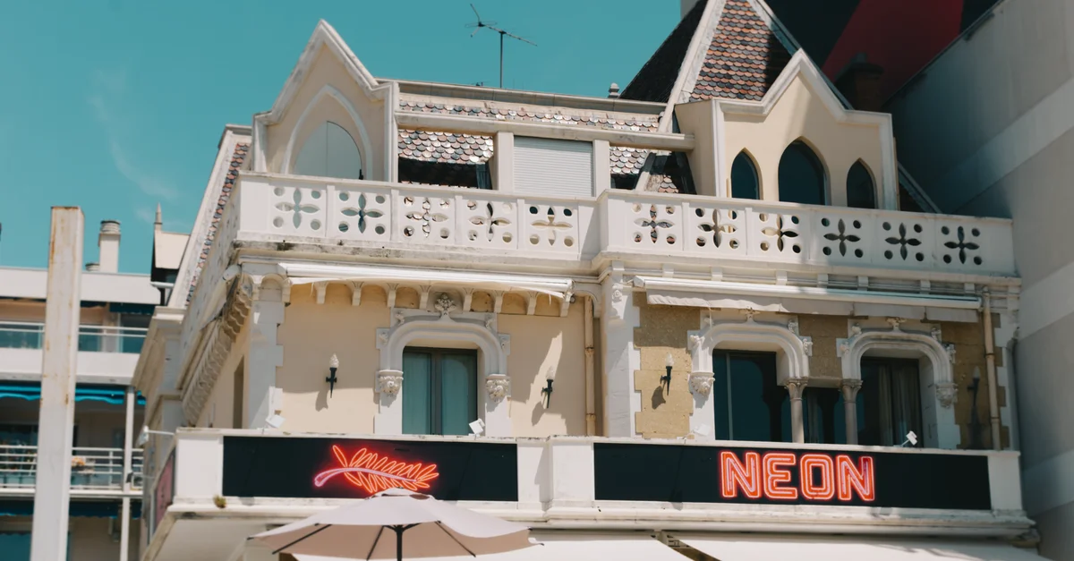 Un bâtiment français classique avec des enseignes lumineuses à Cannes, Provence-Alpes-Côte d'Azur, France.