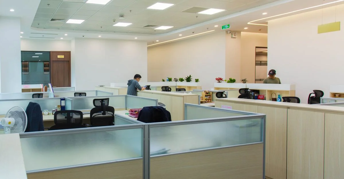 Bureau moderne et spacieux à aire ouverte avec postes de travail et lumière naturelle, optimal pour la productivité.